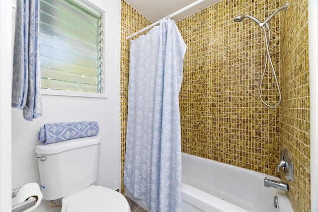 bathroom with toilet and shower / bath combo with shower curtain