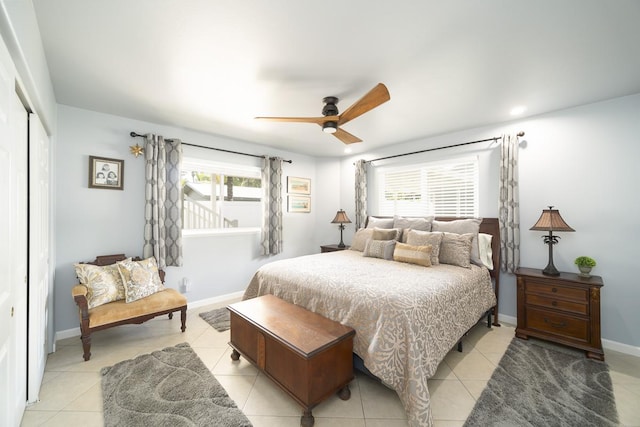 bedroom featuring multiple windows, a closet, ceiling fan, and light tile patterned flooring