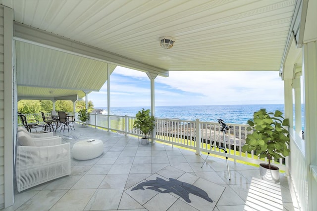 view of patio with a water view and a view of the beach