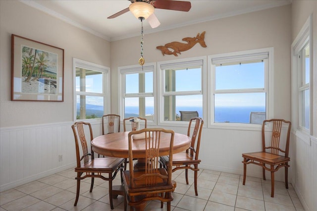 dining area featuring light tile patterned floors, a water view, a wealth of natural light, and ceiling fan