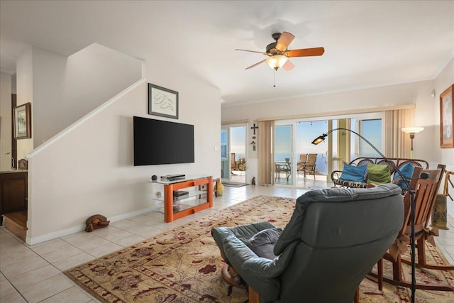 tiled living room with ceiling fan and ornamental molding