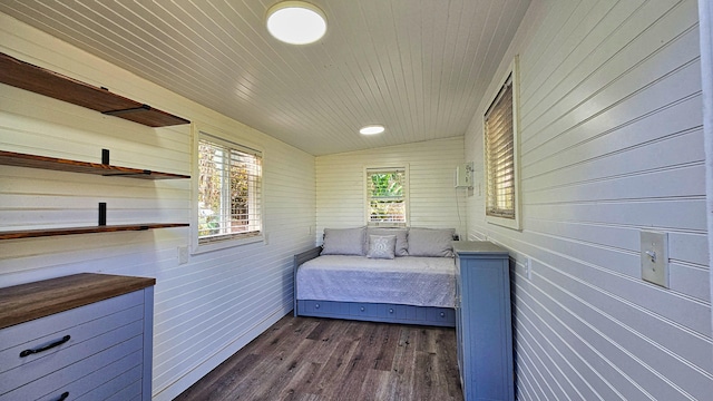 unfurnished bedroom with wooden walls, dark wood-type flooring, and lofted ceiling