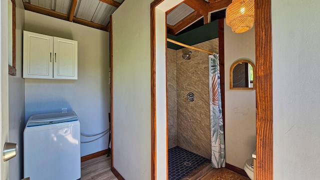 washroom with cabinets, wood-type flooring, and washer / clothes dryer