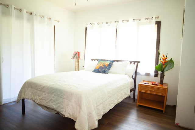 bedroom with dark hardwood / wood-style flooring