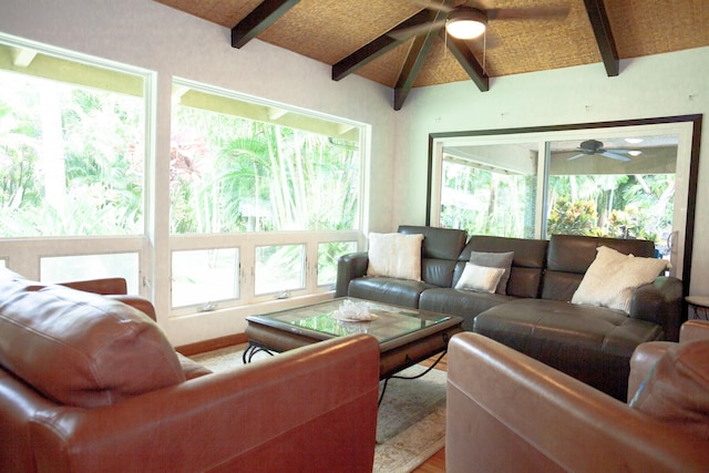 living room with a healthy amount of sunlight, ceiling fan, and lofted ceiling with beams