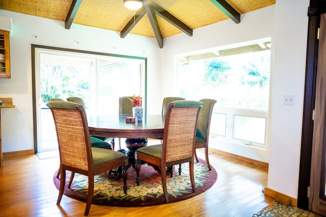 dining area with hardwood / wood-style floors and lofted ceiling with beams