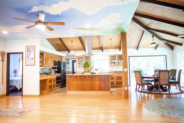 kitchen featuring ceiling fan, sink, stainless steel microwave, lofted ceiling with beams, and light wood-type flooring