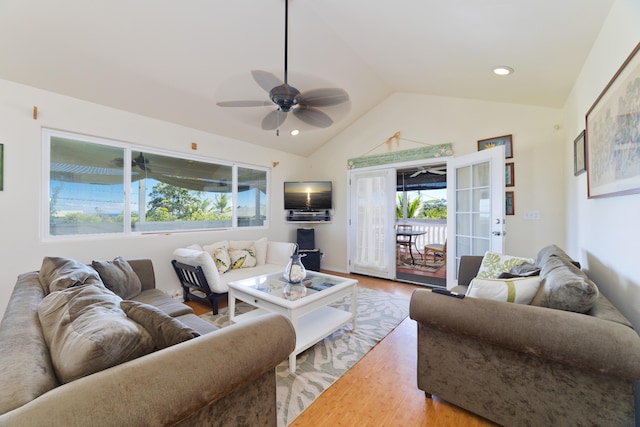 living room with a wealth of natural light, french doors, vaulted ceiling, and hardwood / wood-style flooring