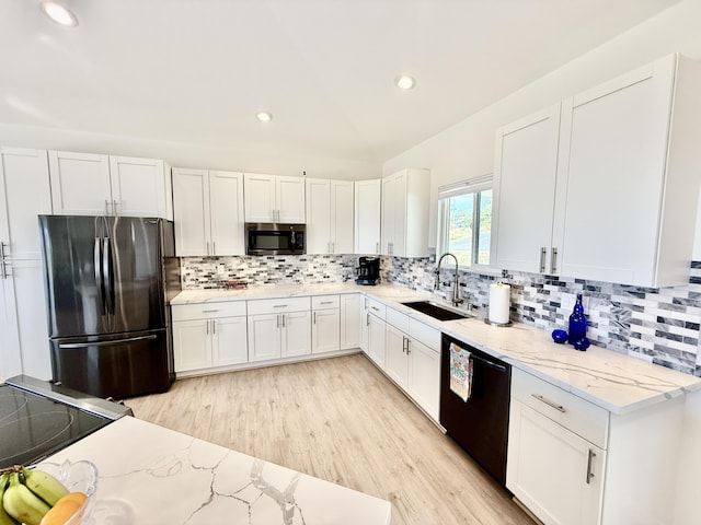 kitchen with light stone countertops, sink, stainless steel appliances, light hardwood / wood-style flooring, and white cabinets