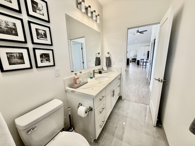 bathroom with vanity, toilet, and ceiling fan