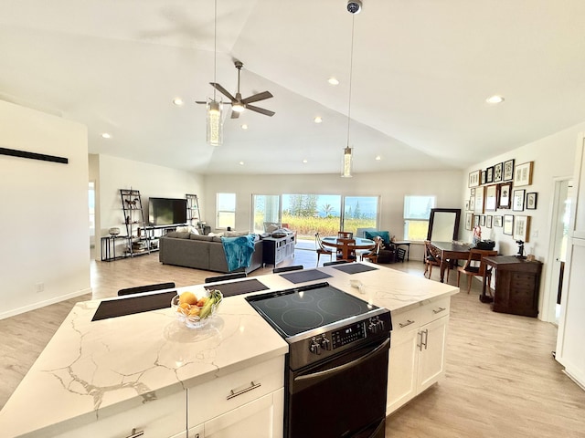 kitchen featuring white cabinetry, electric range, hanging light fixtures, and light stone countertops