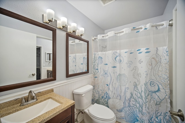 bathroom featuring walk in shower, vanity, and toilet