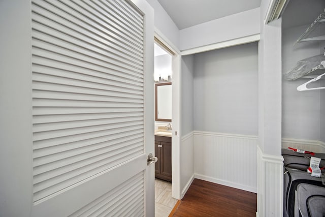 walk in closet with wood-type flooring and sink