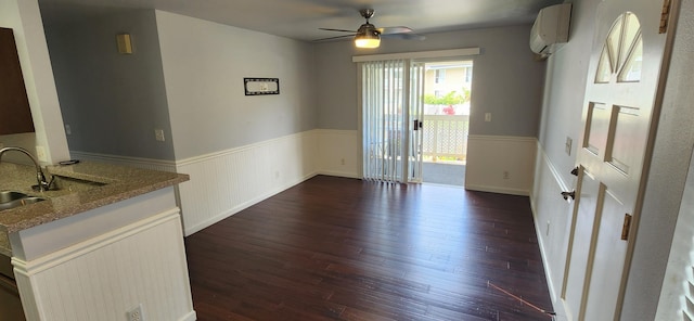 interior space with a wall unit AC, ceiling fan, dark wood-type flooring, and sink