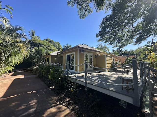 rear view of property featuring french doors and a deck