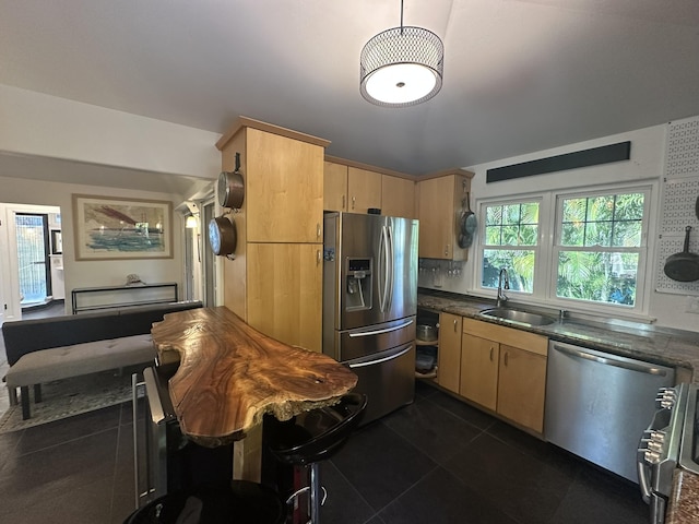 kitchen with dark tile patterned flooring, sink, appliances with stainless steel finishes, light brown cabinetry, and dark stone counters