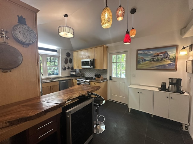 kitchen with butcher block counters, stainless steel appliances, beverage cooler, hanging light fixtures, and vaulted ceiling