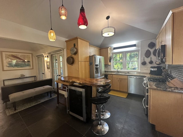 kitchen featuring pendant lighting, appliances with stainless steel finishes, lofted ceiling, wine cooler, and tasteful backsplash