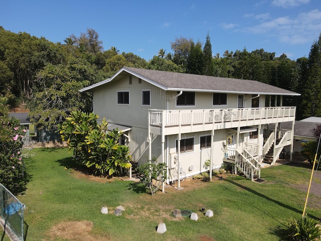 rear view of property with a wooden deck and a yard