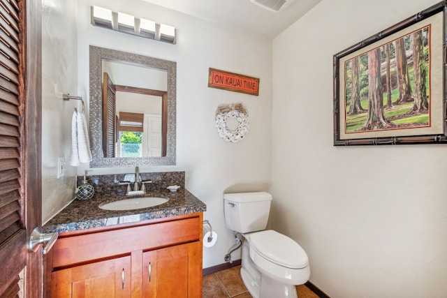 bathroom featuring toilet, vanity, and tile patterned floors