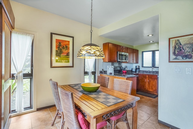 kitchen with decorative light fixtures, a wealth of natural light, and light tile patterned floors