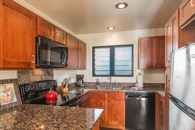 kitchen with sink, dark stone countertops, and black appliances