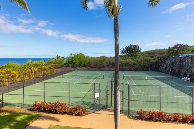 view of tennis court with a water view