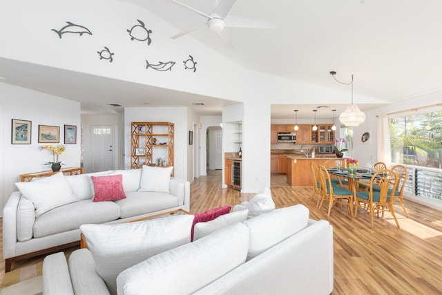 living room featuring light wood-type flooring, wine cooler, and lofted ceiling