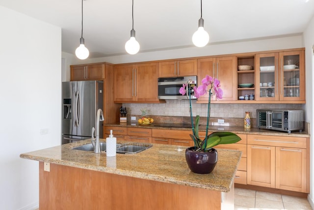 kitchen featuring sink, decorative light fixtures, light stone counters, and appliances with stainless steel finishes