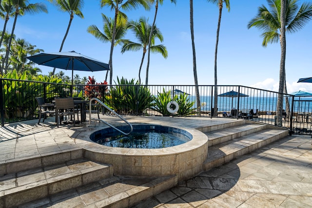 view of swimming pool featuring a community hot tub and a water view