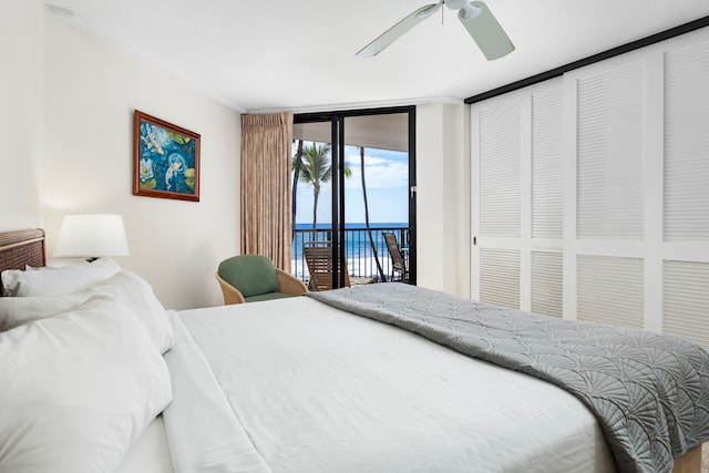 bedroom with ceiling fan, access to exterior, and a wall of windows