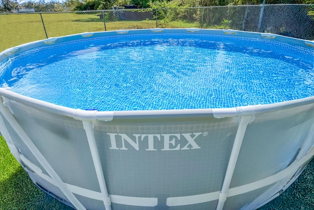 view of swimming pool with a yard