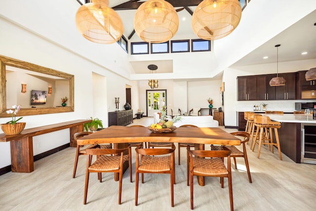 dining space with a towering ceiling and wine cooler