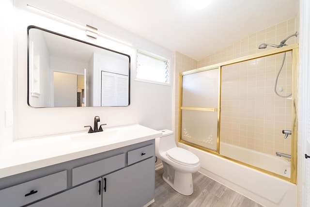 full bathroom with vanity, toilet, bath / shower combo with glass door, and wood-type flooring