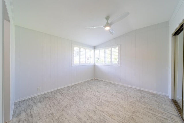 unfurnished bedroom featuring ceiling fan, light hardwood / wood-style floors, a closet, and vaulted ceiling