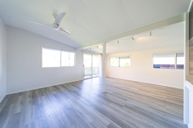 spare room featuring ceiling fan, hardwood / wood-style flooring, lofted ceiling, and track lighting