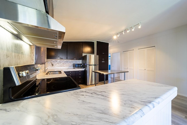 kitchen with sink, backsplash, extractor fan, and appliances with stainless steel finishes