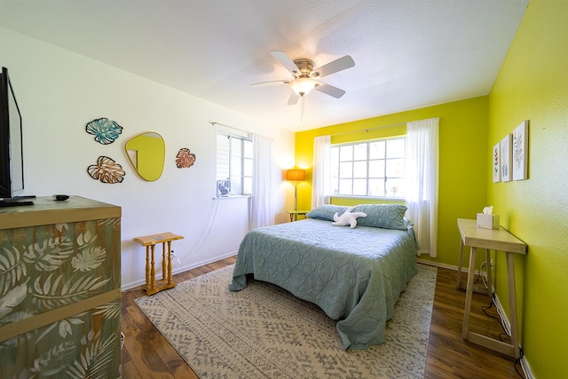 bedroom with dark hardwood / wood-style flooring and ceiling fan