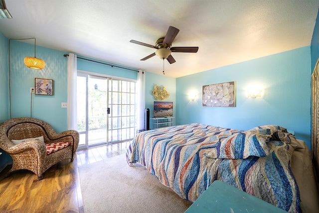 bedroom with hardwood / wood-style flooring, ceiling fan, a textured ceiling, and access to outside