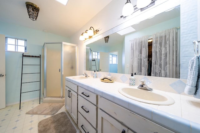 bathroom with vanity, a shower with shower door, and plenty of natural light