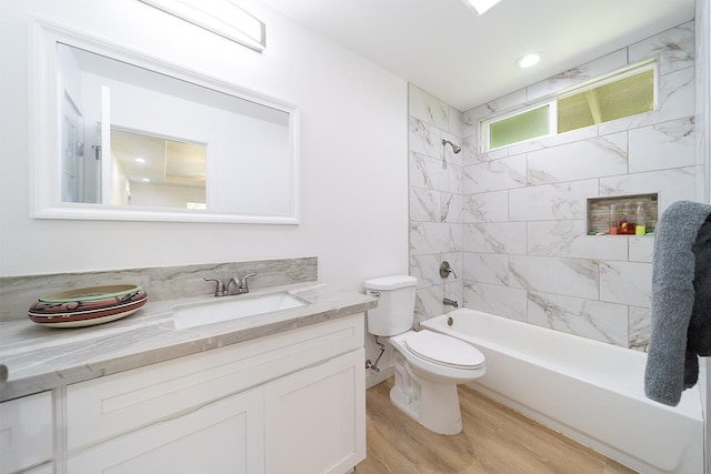 full bathroom featuring tiled shower / bath, vanity, toilet, and hardwood / wood-style floors