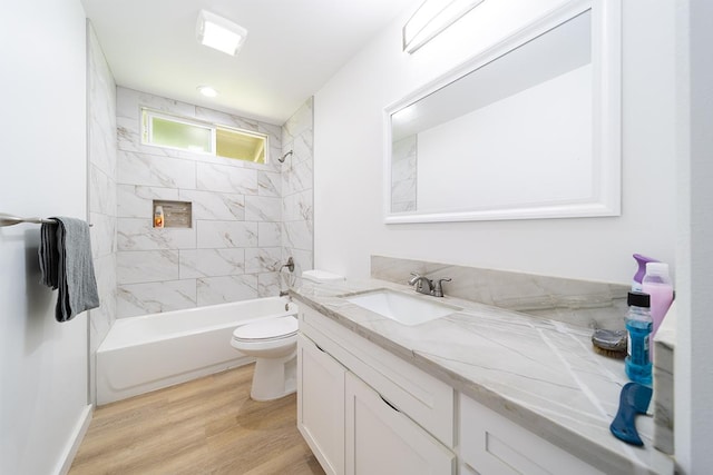 full bathroom featuring vanity, tiled shower / bath, wood-type flooring, and toilet