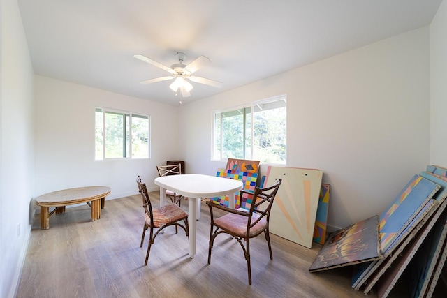 dining area featuring wood-type flooring, a healthy amount of sunlight, and ceiling fan