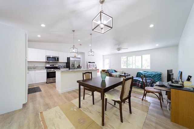 dining room with ceiling fan, lofted ceiling, and light hardwood / wood-style flooring