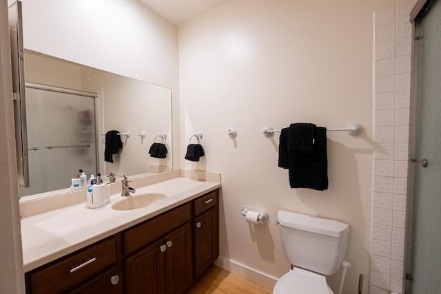 bathroom with vanity, toilet, and a shower with shower door