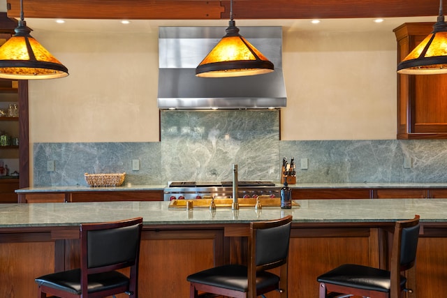 kitchen featuring a kitchen breakfast bar, light stone countertops, and decorative backsplash