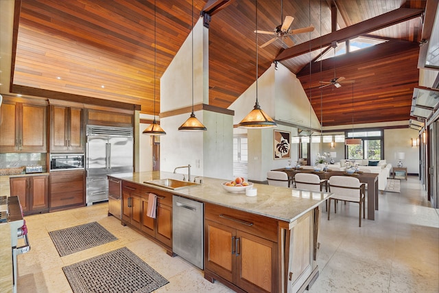 kitchen featuring built in appliances, sink, high vaulted ceiling, and a center island with sink