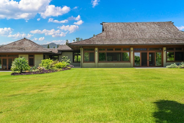 rear view of property featuring a yard