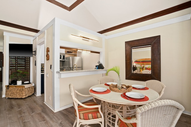 dining room featuring hardwood / wood-style flooring and vaulted ceiling