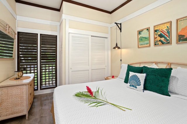 bedroom featuring access to exterior, crown molding, a closet, and dark wood-type flooring